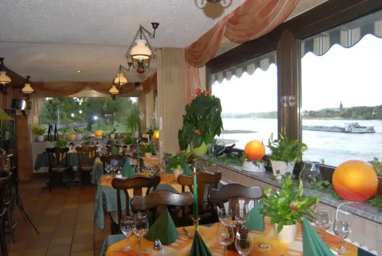 Gedeckte Tische im Restaurant an den Fenstern mit Rheinblick
